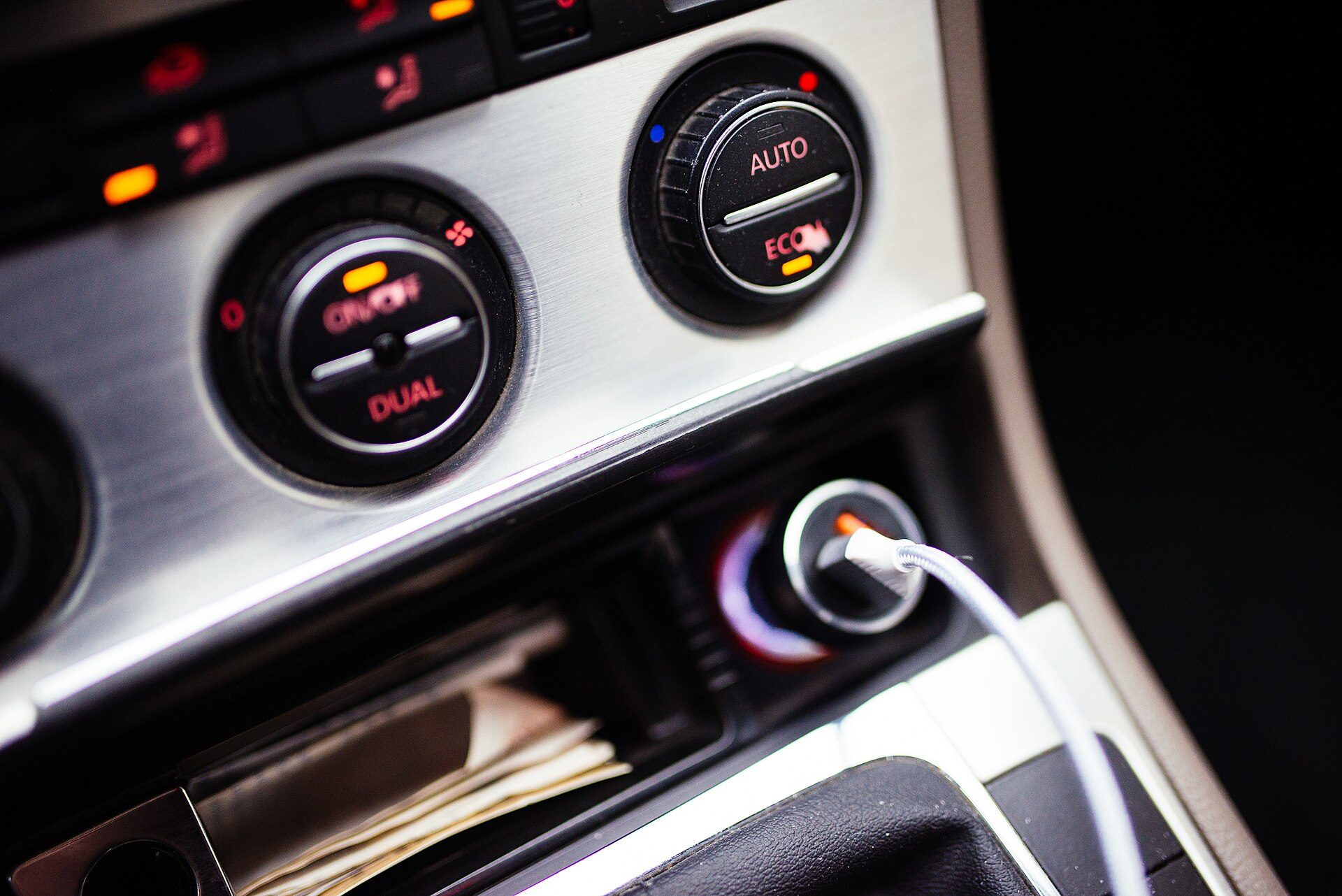Car centre console at night with a charging cable